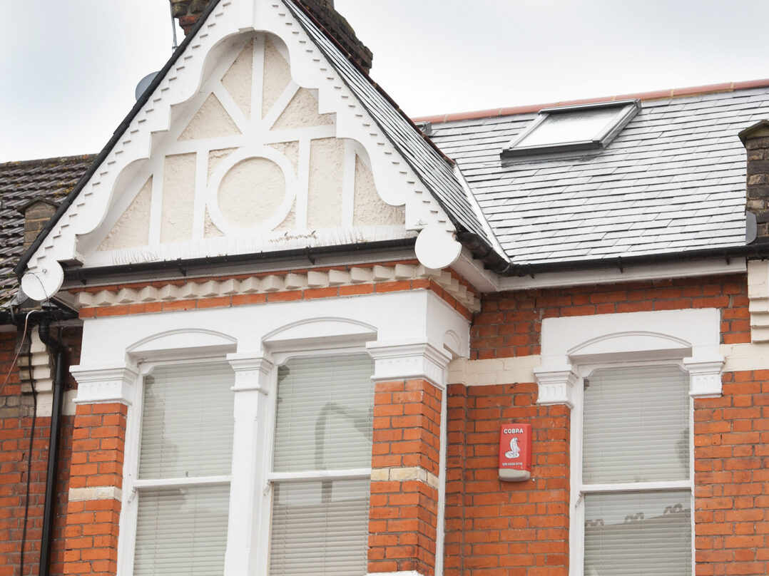 Exterior of a townhouse showing a single Velux window.